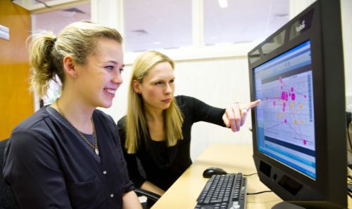 Staff and student looking at material on PC screen