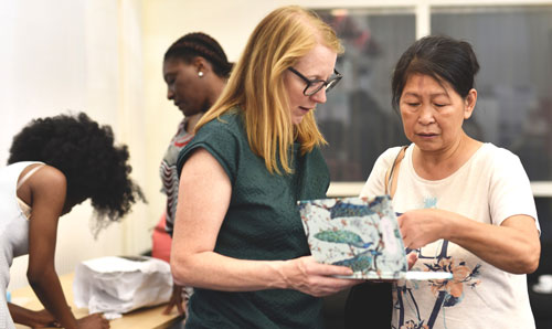 Photo: Two people looking at a book at an event