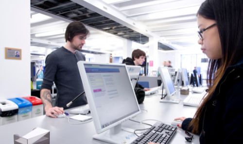 Students looking at PC screens in Main Library