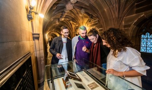 Visitors to the Transitions in Print exhibition view an item