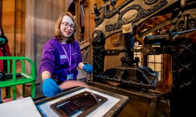 Rylands staff member using the Columbian printing press.