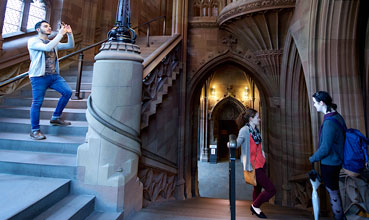 A visitor taking pictures in the historic staircase