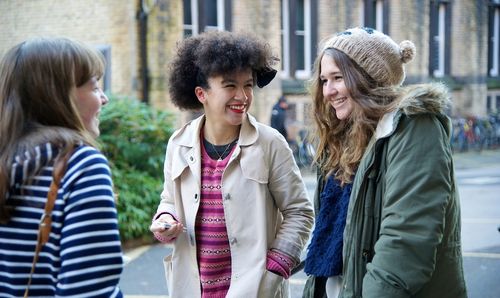 Students chatting and smiling outside the entrance to Main Library