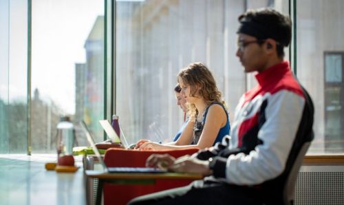 Three students sat in a row working in AGLC